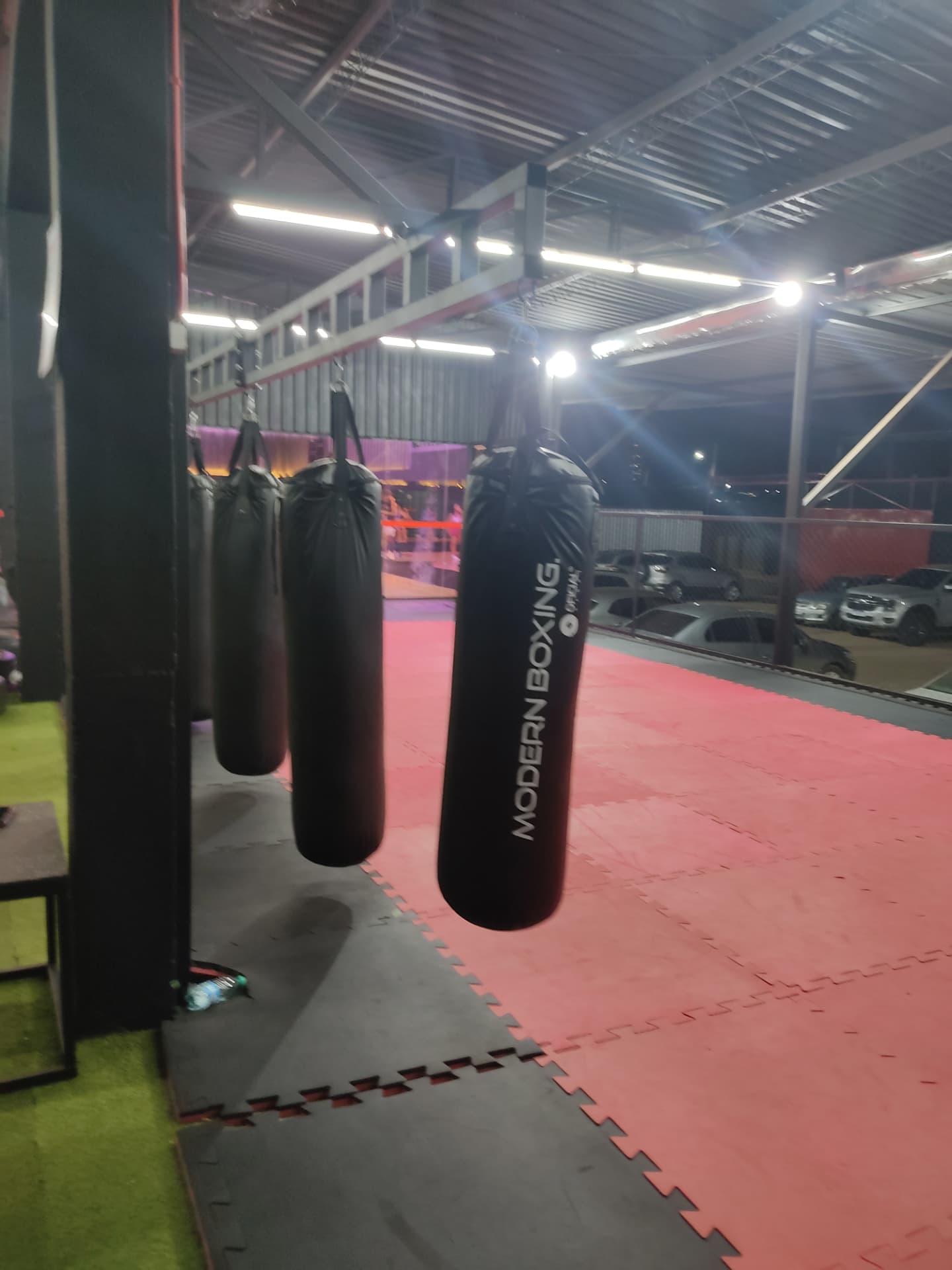 Área de boxe com sacos de pancada